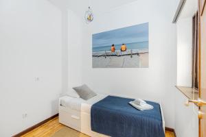 a bedroom with a bed and a painting on the wall at A Lodge in Blue in Aveiro