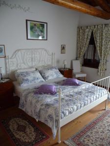 a bedroom with a white bed with purple pillows at Agriturismo Borgovecchio in Romàns dʼIsonzo