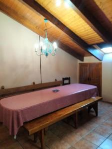 1 cama grande de color púrpura en una habitación con techo de madera. en Casa los Ancares, en Vega de Espinareda