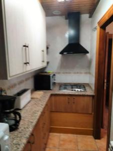 a kitchen with wooden cabinets and a stove top oven at Casa los Ancares in Vega de Espinareda