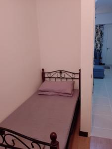een klein bed in een kamer met een bedframe bij Traveller Residence by Celandine in Manilla