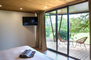 a bedroom with a bed and a large glass window at Manoir le Roure in Châteauneuf-du-Rhône