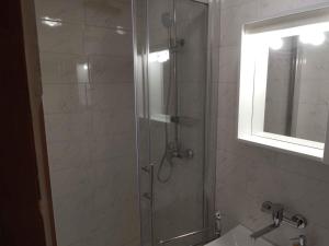 a bathroom with a shower with a sink and a mirror at Holiday home Senj 1 in Senj