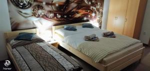 Penzion Svitavy في سفيتافي: سريرين في غرفة نوم مع لوحة على الحائط