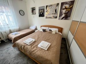 two beds in a small room with posters on the wall at Cute little apartment in Belgrade
