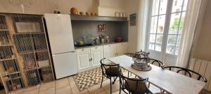 eine Küche mit einem Tisch und Stühlen sowie einem Kühlschrank in der Unterkunft Le Rocher appartement Cotignac in Cotignac