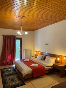 a bedroom with a bed with a red blanket at Mountain Hotels "Aroanides" in Planitéron