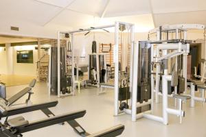 une salle de sport avec plusieurs tapis de course et machines dans l'établissement Thalazur Carnac - Hôtel & Spa, à Carnac