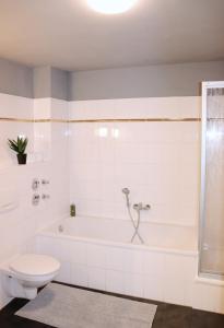 ein Badezimmer mit einer weißen Badewanne und einem WC in der Unterkunft Studio - ONE / Netflix Balkon Wifi in Chemnitz