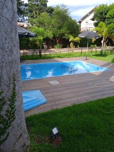 a swimming pool in a yard next to a tree at Pousada Diamante in Bonito
