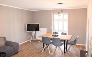 ein Wohnzimmer mit einem Tisch und Stühlen sowie einem TV in der Unterkunft Studio - ONE / Netflix Balkon Wifi in Chemnitz