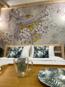 ein Zimmer mit 2 Betten und einem Tisch mit einem Glas darauf in der Unterkunft OIKIASTUDIOS2 in Patras