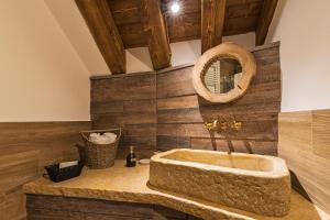 uma casa de banho com uma banheira de pedra e um espelho. em Malga Laben em Velo Veronese