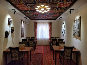 a dining room with tables and chairs and a ceiling at Islam Khodja in Khiva