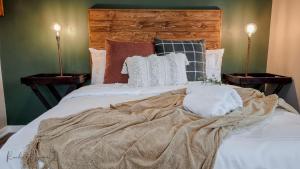 a bed with a blanket on it with two lamps at The Aloe in East London