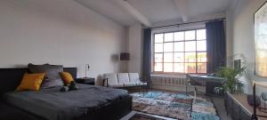 a bedroom with a bed and a large window at Loft 46 - Long And Shortstay in Berlin