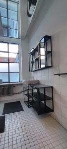 - une salle de bains avec une table et 2 fenêtres dans la chambre dans l'établissement Loft 46 - Long And Shortstay, à Berlin