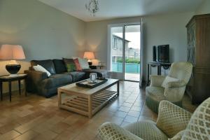 salon z kanapą, stołem i krzesłami w obiekcie Côté Plage - Maison pour 12 vue mer w mieście Saint-Cast-le-Guildo