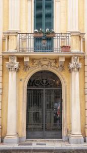 un edificio con una puerta grande y un balcón en Opera Relais 85, en Messina