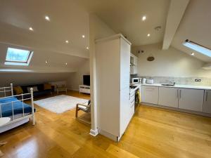 a kitchen and living room with a bed in a room at City Link - Mapperley Park Penthouse - Free parking,tram&bus,HSwifi,7ppl by KP in Nottingham