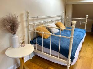 a white bed with pillows and a table in a room at City Link - Mapperley Park Penthouse - Free parking,tram&bus,HSwifi,7ppl by KP in Nottingham