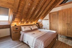 sypialnia z łóżkiem i drewnianym sufitem w obiekcie Malga Laben w mieście Velo Veronese