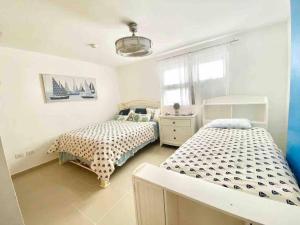 Un dormitorio con dos camas y una ventana. en 3 Bedrooms At Marbella Beachfront Juan Dolio no820, en Juan Dolio