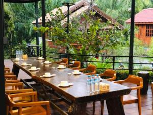 een lange tafel in een restaurant met stoelen bij กอบสุข รีสอร์ท 2 k11 in Ban Ton Liang