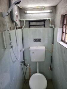 a small bathroom with a toilet and a shower at Lot 85 Seremban Town New Cozy Homestay Lobak Roomstay in Seremban +38 photos