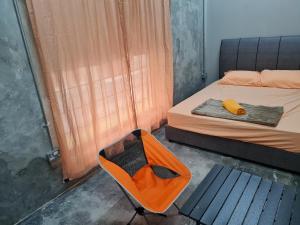 a small room with a bed and a chair at Lot 85 Seremban Town New Cozy Homestay Lobak in Seremban