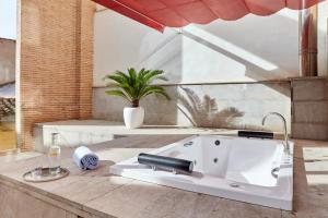 a white sink on a patio with a plant at Hotel Macià Granada Five Senses Rooms & Suites in Granada