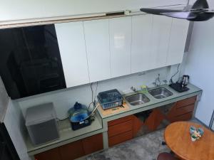 a small kitchen with two sinks and a table at Lot 85 Seremban Town New Cozy Homestay Lobak Roomstay in Seremban