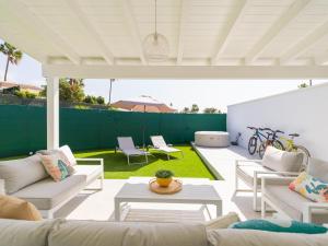 a patio with white furniture and a green fence at Aquarium Bungalow private jacuzzi, 3 bedrooms, AC and Bikes in Maspalomas