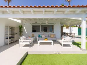 a patio with white furniture and a white pergola at Aquarium Bungalow private jacuzzi, 3 bedrooms, AC and Bikes in Maspalomas