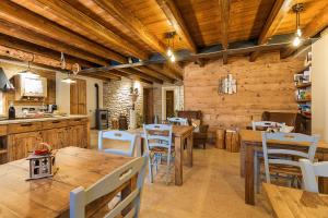 una cocina con paredes de madera, mesas de madera y sillas en Malga Laben, en Velo Veronese