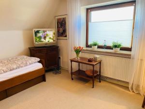 1 dormitorio con 1 cama, TV y ventana en Ferienhaus mit Charme DEL, en Delmenhorst