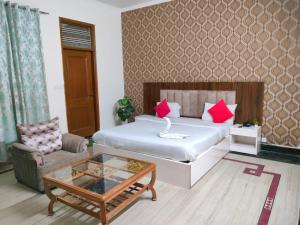 a bedroom with a bed and a table and a couch at Viraj Guest House in Noida