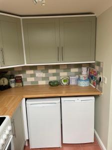 a kitchen with white cabinets and wooden counter top at The Garden House in Bishop Burton