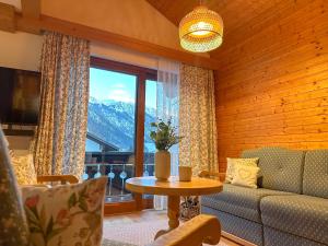 a living room with a couch and a table and a window at Ferienwohnung Auszeit in Bad Hindelang