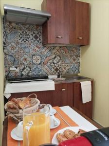 una cucina con tavolo, pane e succo d'arancia di Quick Home - Casetta Blu a Gaglianico