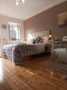una camera con 2 letti e un pavimento in legno di Quick Home - Casetta Blu a Gaglianico