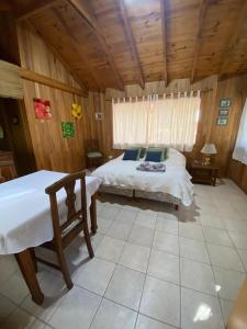 1 dormitorio con cama y techo de madera en Cabaña Los Helechos en San Martín de los Andes