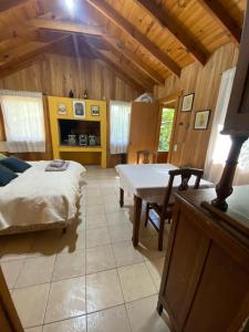 1 dormitorio con 1 cama y 1 mesa en una habitación en Cabaña Los Helechos en San Martín de los Andes