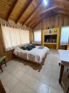 1 dormitorio con cama y techo de madera en Cabaña Los Helechos en San Martín de los Andes