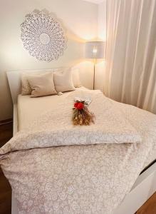 Un dormitorio con una cama blanca con una flor. en Lakeside Apartment for Business and Leisure incl parking space en Cham