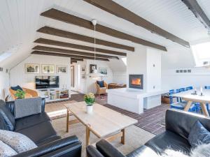 a living room with couches and a table and a fireplace at Holiday home Henne CXXVIII in Henne Strand