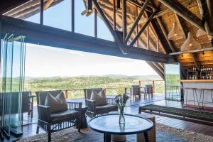 a room with a table and chairs and windows at Mavela Game Lodge in Manyoni Private Game Reserve