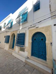 un bâtiment avec une porte bleue dans une rue dans l'établissement Dar Lilia Monastir, à Monastir