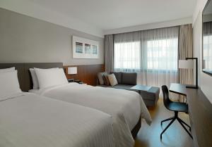 een hotelkamer met 2 bedden en een bank bij Athens Marriott Hotel in Athene