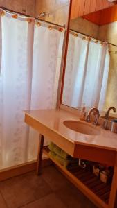 y baño con lavabo y espejo. en Casa de Montaña Valle Escondido en San Martín de los Andes